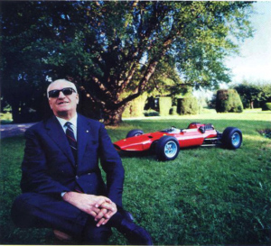 Enzo Ferrari pose devant un modèle réduit de l'une de ses voitures