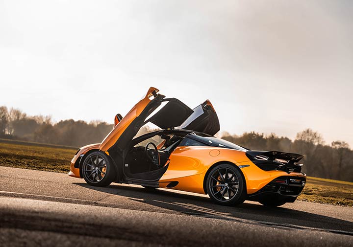McLaren 720S sur circuit de profil les portes ouvertes